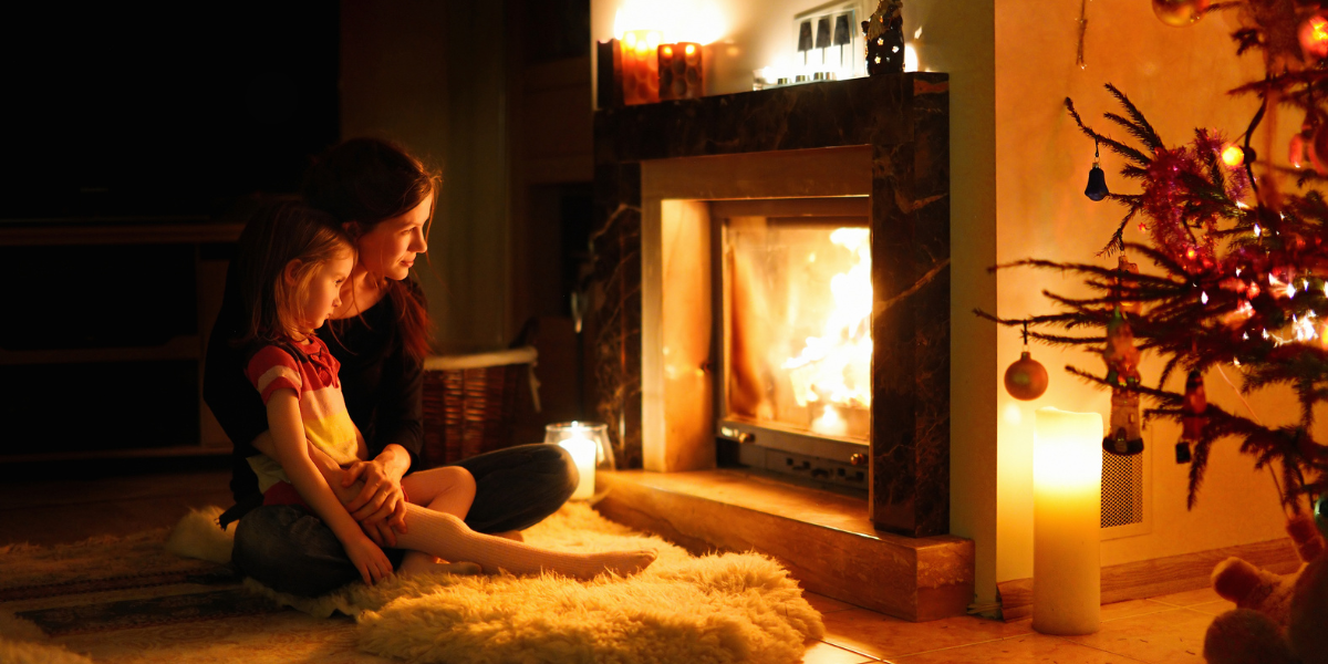 A peaceful mother and daughter sitting by the fireplace during a Christmas evening