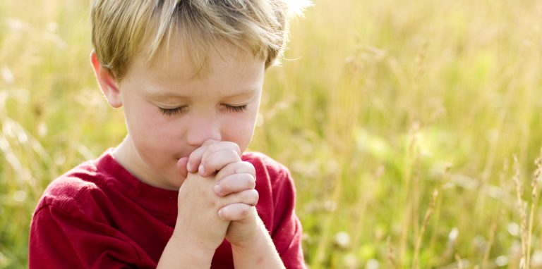 Child praying outdoors