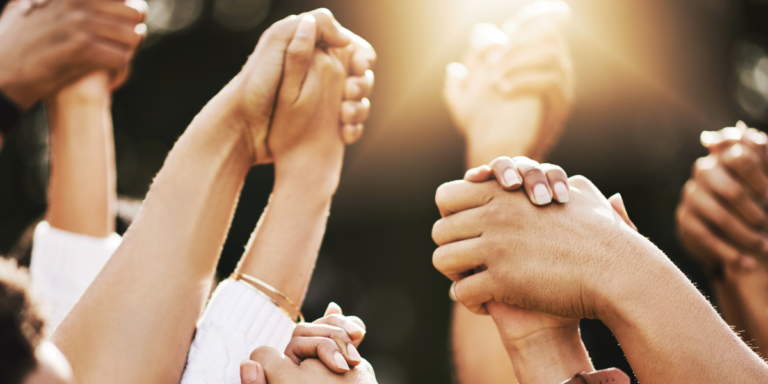 A group of people holding hands and raising them in the air