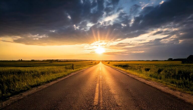 A long county 2 lane road with a sunrise